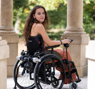 Femme dans un fauteuil roulant avec une motorisation Minotor 2.1 de Benoit Systemes.